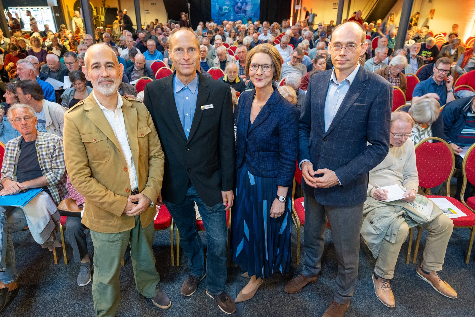Mitwirkende des Abends mit Anja Floetenmeyer-Woltmann in der ersten Reihe vor dem vollen Saal