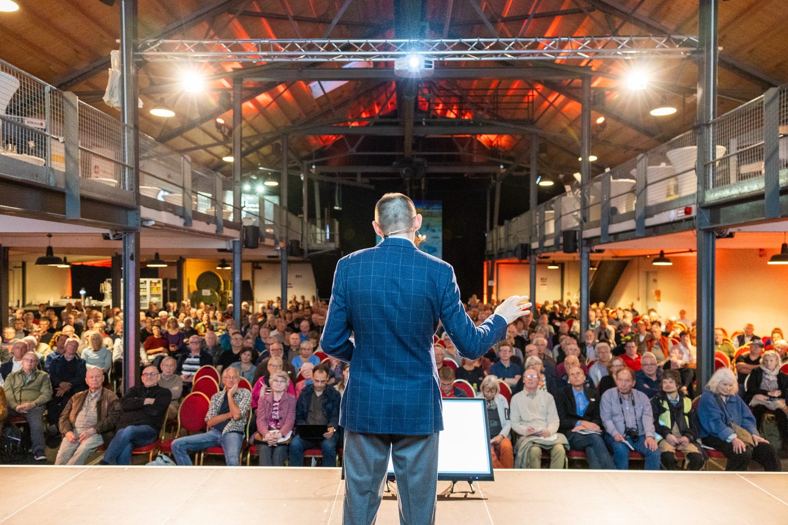 Dr. Marek Miara spricht zum Publikum, Blick von der Bühne in die Halle