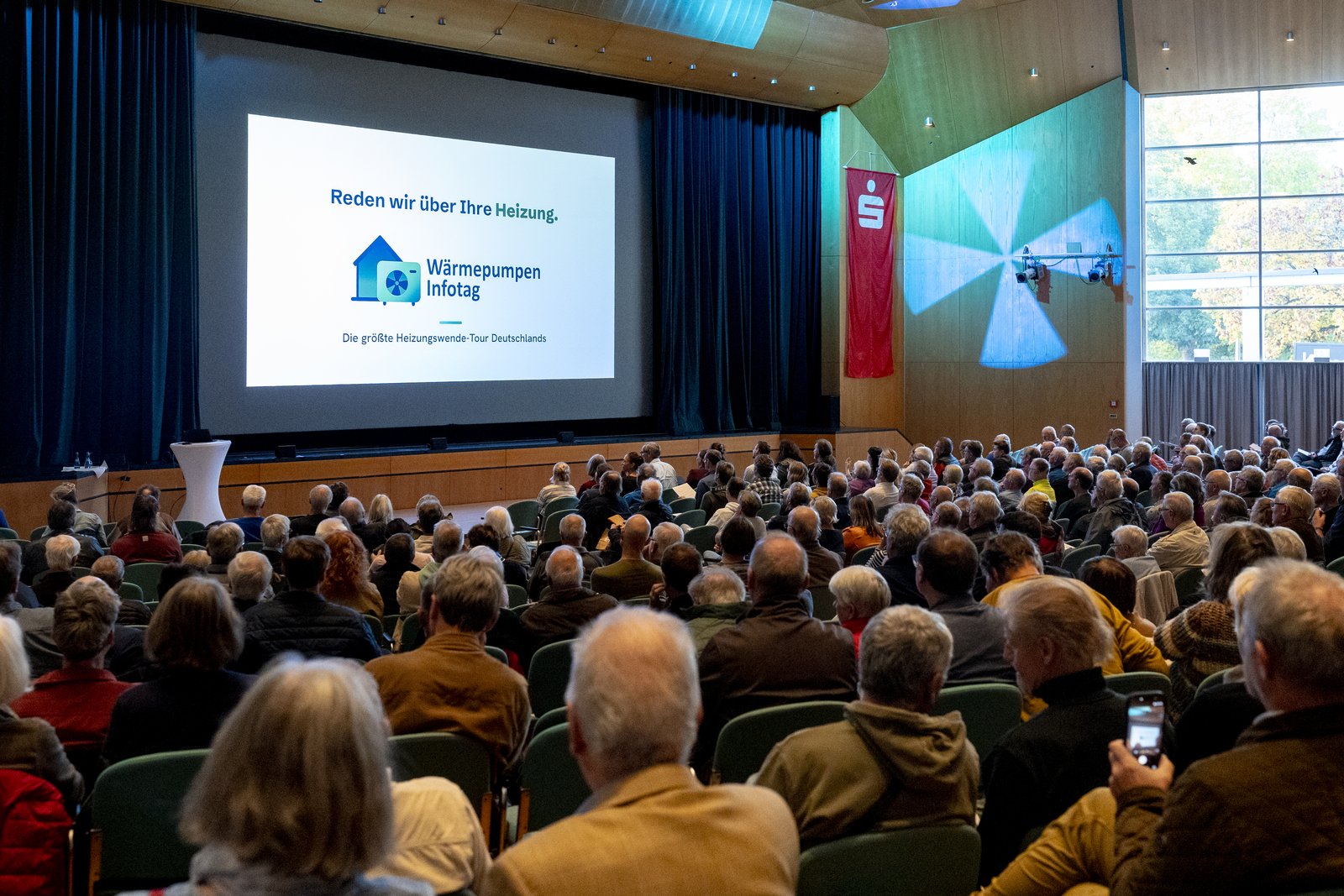 Blick über das volle Publikum auf die Startfolie Reden wir über Ihre Heizung