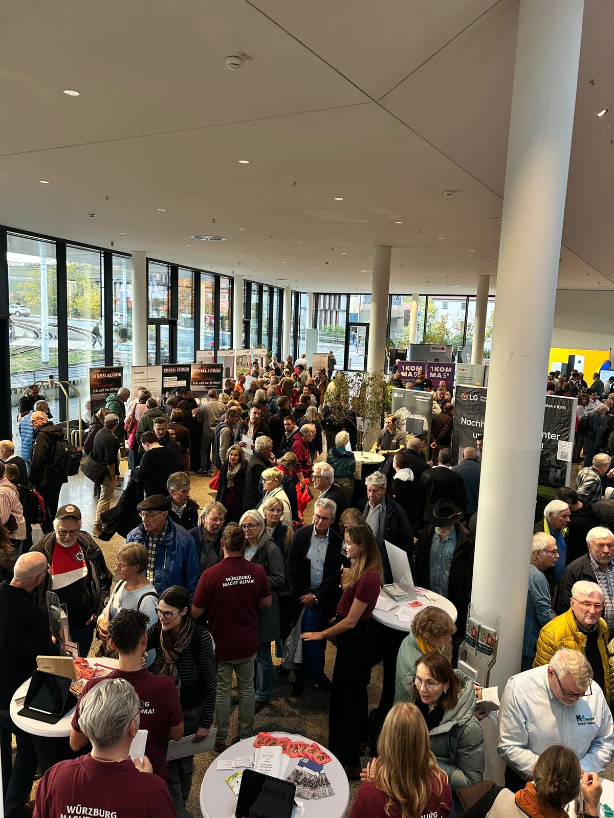 Gedränge im Foyer, Standteams im Gespräch mit Besucher:innen