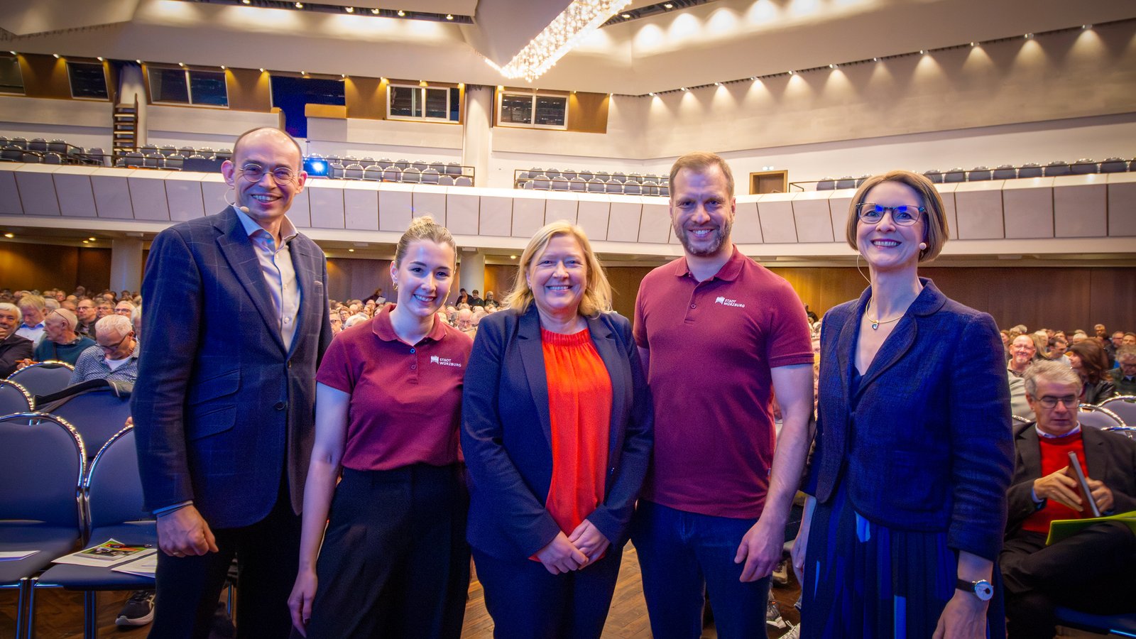 Gruppenbild auf der Bühne mit Dr. Marek Miara, Anja Floetenmeyer-Woltmann und dem Team der Stadt Würzburg